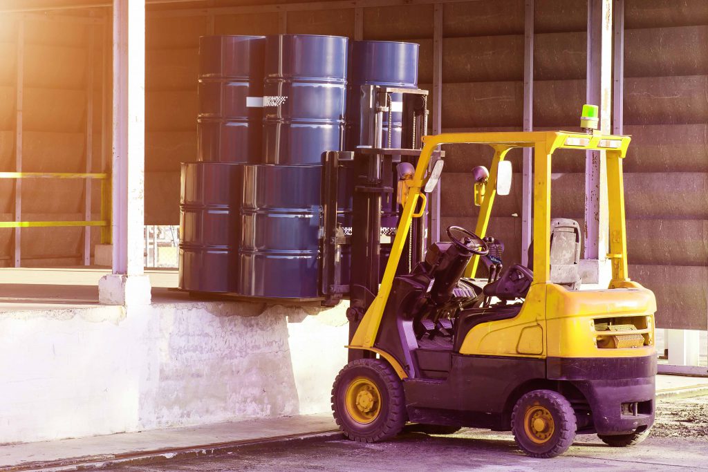 Small oil bins are transported by machine.