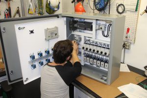 Employee working on an electronic control panel.