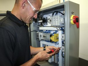 A JHFoster employee configures an electrical control panel.