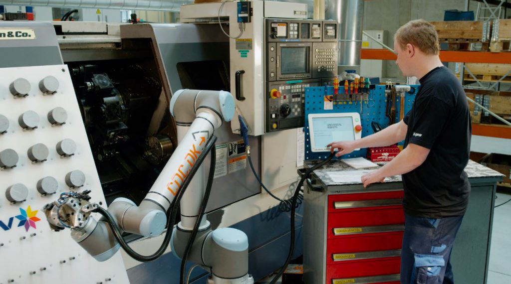 A JHFOSTER employee programs a robot to complete a task.