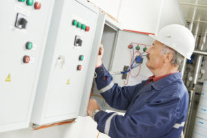 Technician working on electrical control panel