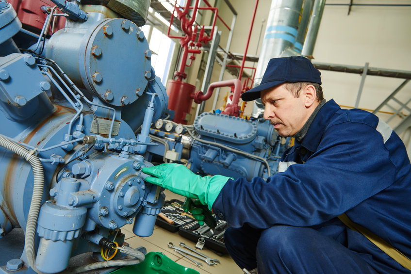 Service technician working on industrial air compressor